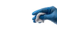 Medical professional hand in blue latex glove holding white protective face mask isolated on white background for healthcare and safety concepts.