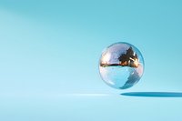 Shiny disco ball floating against turquoise background casting soft shadows, minimalist party decoration concept for entertainment and celebration design.