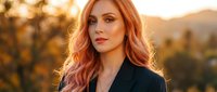 Professional redhead businesswoman in black blazer during golden hour sunset with mountain landscape background for corporate and lifestyle marketing.