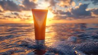 Orange cosmetic tube on ocean wave at dramatic sunset with golden sunlight reflection. Natural skincare and summer beauty product photography for spa and wellness.