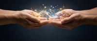 Two male hands with medium skin tone cupped together, releasing glowing golden light particles and sparkles against a dark background, symbolizing sharing, giving, magic, and energy transfer.