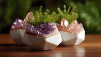 Modern geometric concrete planters with raw amethyst and rose quartz crystals decorated with fresh green moss, creating zen garden atmosphere on wooden surface.