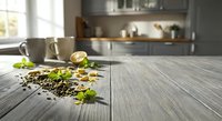 Fresh herbs and spices scattered on wooden kitchen counter with modern gray cabinets and natural lighting creating culinary cooking atmosphere.
