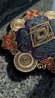 Ornate embroidered patch with geometric mandala design featuring purple swirls, red roses and golden circles on dark fabric background for fashion decoration.