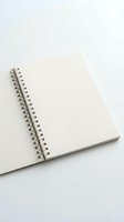 Open blank spiral notebook with white pages and metal binding on neutral background for creative writing and note-taking projects.
