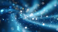 Glowing blue particles and light rays create magical atmosphere with bokeh effect and blurred motion trails on dark background. Suitable for abstract designs.
