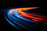 Dynamic light trails create vibrant streaks of blue and orange colors flowing across dark background for modern technology and speed concepts.