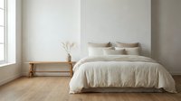 Minimalist bedroom interior with natural light from window, wooden bench, neutral bedding, and dried flowers in vase for home decor and design inspiration.
