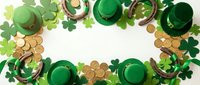 St. Patrick's Day festive frame with green top hats, shamrock clovers, golden coins and horseshoes on white background for Irish holiday celebration.