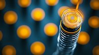 Glowing spiral metal coil with golden wire wrapped around spring on dark background with blurred bokeh lights creates abstract technological composition.