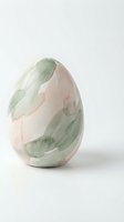 Handcrafted ceramic egg with marbled green and pink glazed finish on white background for home decor and Easter celebration design projects.
