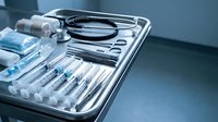 Sterile medical instruments and stethoscope arranged on surgical tray in hospital operating room for healthcare procedures and patient examination.