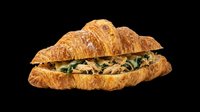Croissant sandwich with green leafy filling isolated on transparent background, ready for menu design, food packaging, restaurant graphics, print-on-demand products, and culinary marketing materials.