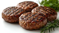 Grilled beef patties with charred grill marks and caramelized crust, garnished with fresh rosemary and parsley sprigs on neutral background.