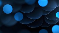 Abstract background with glowing blue circular bokeh lights creating depth and pattern against dark backdrop, suitable for technology and modern designs.