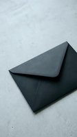 Black envelope on concrete surface for business correspondence and mailing needs.