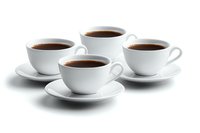 Four white porcelain coffee cups and saucers arranged symmetrically with fresh dark coffee on white background, isolated for commercial and design use.