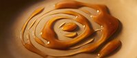 Creamy peanut butter swirl with smooth texture and glossy finish, ideal for food and culinary design projects.