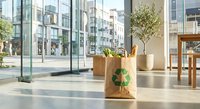 Modern office lobby with recycling cardboard boxes and green plants in bright urban building interior with glass windows and contemporary furniture.