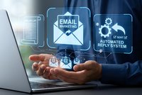 Business professional showcasing digital email marketing automation technology with holographic interface icons floating above hands near laptop computer.