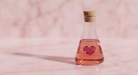 Pink love potion bottle with heart symbol on marble surface for romantic Valentine's Day concepts and magical themed designs.