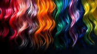 Vibrant wavy rainbow hair strands flowing against dark background showcasing multicolored dyed hairstyles for salon and beauty industry marketing materials.