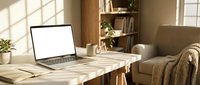 Modern home office workspace with open laptop displaying blank white screen on wooden desk near comfortable armchair and bookshelf in warm natural sunlight.