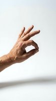 Senior man hand making OK gesture on white background isolated for communication and approval concepts.