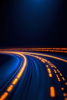 Glowing orange light trails curve along dark blue highway at night, creating dynamic motion effect with illuminated road markers and streaking lights.