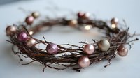 Rustic twig wreath decorated with pink and gold ornament balls for holiday home decor and seasonal crafting projects.
