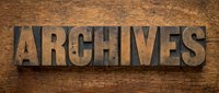 Word Archives in vintage letterpress wood type blocks against rustic grunge wooden background, retro typography concept.