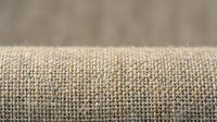 Close-up of natural linen fabric with woven texture, neutral beige tone. Suitable for textile, interior design, and fashion projects.