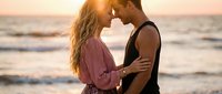 Young couple embracing intimately on beach at golden hour sunset, romantic moment by ocean waves, love and connection concept for lifestyle content.