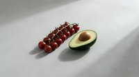 Fresh cherry tomatoes on vine and halved avocado on light gray surface with soft shadows, healthy eating and nutrition concept.
