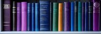 Row of vintage hardcover books in various shades of blue, purple, and green standing upright on wooden shelf, creating colorful library panorama for education concept.