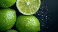 Fresh green limes with water drops on dark background, macro shot showing juicy citrus texture and bright cross section with segments. Food photography.