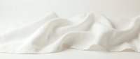 Soft white fabric with gentle folds and waves creating elegant textile texture against neutral background for fashion and interior design projects.