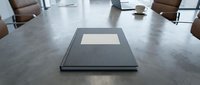 Corporate boardroom meeting table with closed folder and coffee cup in modern office conference room for business presentations.