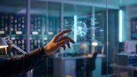 Hand touching futuristic holographic interface with digital data visualization in modern tech office environment for business innovation concepts.