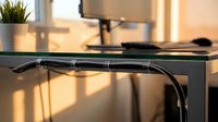 Modern office desk cable management system with black wire organizer tray mounted under workspace for clean professional home office setup.