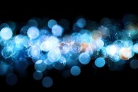 Abstract blue bokeh lights with glowing orbs and sparkles on black background for digital design and creative projects.