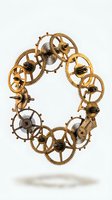 Vintage brass clockwork gears and mechanical parts arranged in oval frame on white background for steampunk design projects.