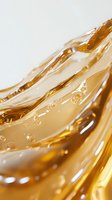 Golden liquid waves with air bubbles creating dynamic flowing pattern in macro photography, abstract background for cosmetic and beauty industry designs.