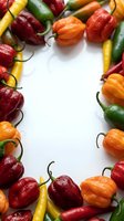 Colorful hot chili peppers frame border on white background with copy space for text. Fresh spicy vegetables arrangement for cooking and seasoning recipes.