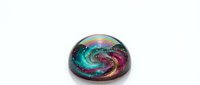 Colorful glass marble with swirling galaxy pattern in turquoise, purple and gold colors isolated on white background for craft and decoration projects.