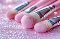 Pink makeup brushes on glittery surface with soft bokeh background, professional cosmetic tools for beauty application and makeup artistry.