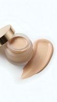Luxury foundation cream jar with golden cap and beige makeup smear on white background for cosmetic advertising and beauty product marketing campaigns.