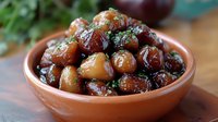 Marinated mixed olives with herbs in ceramic bowl on wooden table for Mediterranean cuisine and appetizer recipes.