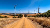 Rural rolling hills against bright blue sky, golden dry grass on sides, sustainable energy landscape in summer countryside.