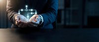 Businessman holding glowing digital network connection in cupped hands representing connectivity, technology innovation and data transfer solutions.